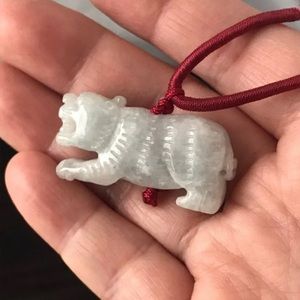 Genuine white jade carved Siberian tiger on a Chinese style cord.